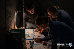 Groupe de deux femmes officiers et d'un homme en train résoudre les énigmes d'un escape game